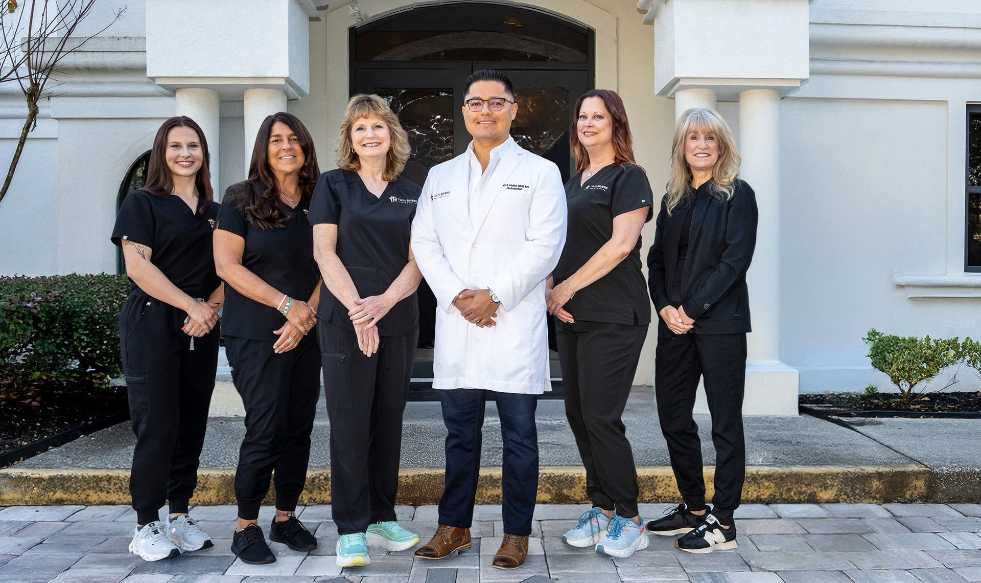 Medical team posing outside building.